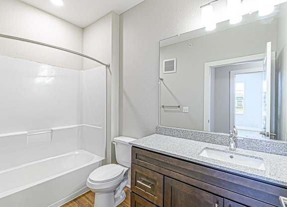 a bathroom with a sink toilet and a mirror at The Fitzroy San Marcos, San Marcos, Texas