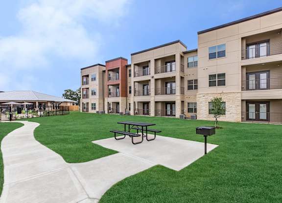 Outdoor courtyard with picnic area and walking path at Sienna at Westover Hills Apartments, San Antonio, TX 78253