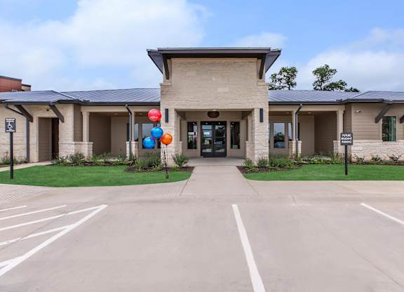 Leasing office entrance with stone facade and metal roof at Sienna at Westover Hills Apartments, San Antonio