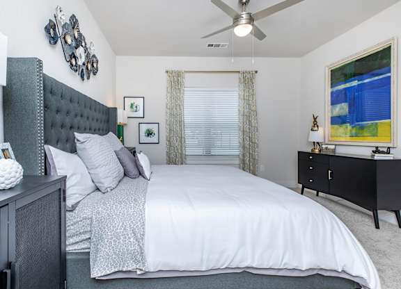 Bedroom with tufted headboard and ceiling fan at Sienna at Westover Hills Apartments, San Antonio, 78253