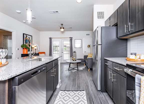 Galley kitchen with dark cabinets and granite counters at Sienna at Westover Hills Apartments, San Antonio, Texas