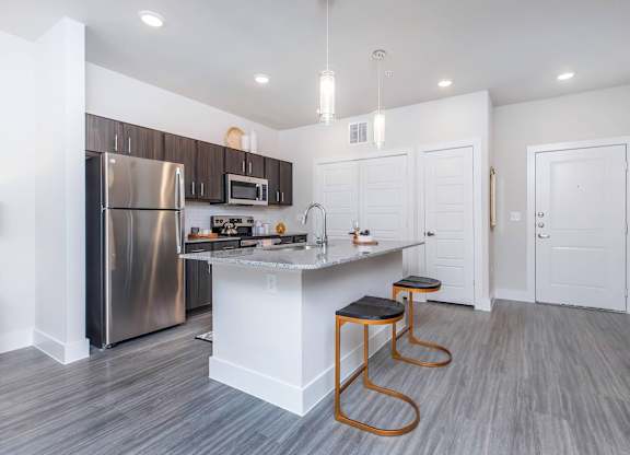 Open concept kitchen with island and bar stools at Sienna at Westover Hills Apartments, Texas