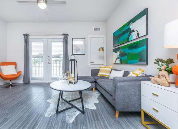 Living room with gray sectional and abstract artwork at Sienna at Westover Hills Apartments, San Antonio, TX
