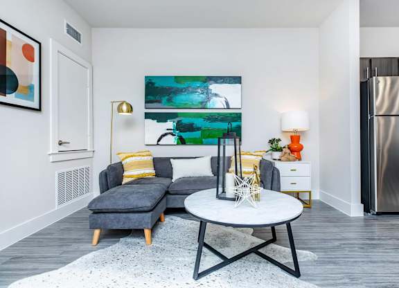 Modern living room with gray chaise lounge and art at Sienna at Westover Hills Apartments, San Antonio, Texas