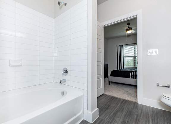 Bathroom with soaking tub and view into bedroom at Sienna at Westover Hills Apartments, San Antonio, TX 78253