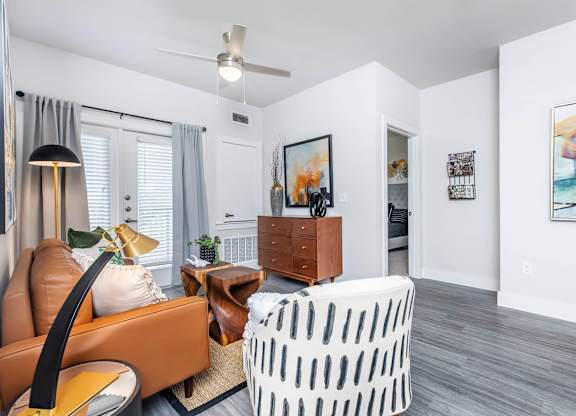 Living room seating area with patterned accent chair at Sienna at Westover Hills Apartments, San Antonio