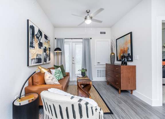 Living room entry with tan sofa and ceiling fan at Sienna at Westover Hills Apartments, Texas