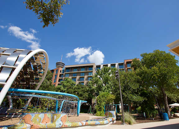 Outdoor playground area with modern climbing equipment at THE'68 Apartments, San Antonio, 78205