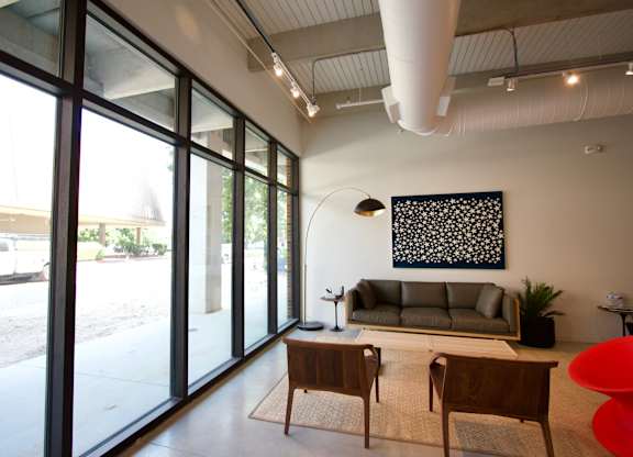 Modern lounge area with floortoceiling windows at THE'68 Apartments, San Antonio, Texas