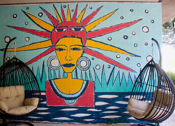 Colorful mural with hanging egg chair seating at THE'68 Apartments, Texas, 78205