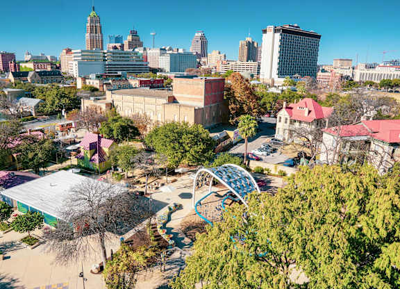 Aerial view of urban park with blue archway at THE'68 Apartments, San Antonio, TX