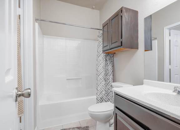 Modern bathroom with white countertop and dark cabinetry at Houston Street Townhomes Apartments, San Antonio, Texas