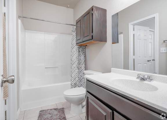 Modern bathroom with vanity and tub at Houston Street Townhomes Apartments, San Antonio