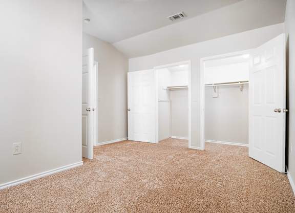 Spacious bedroom with dual walk-in closets at Houston Street Townhomes Apartments, San Antonio, Texas