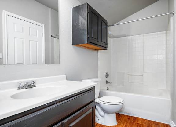 Bathroom with dark vanity and white tile surround at Houston Street Townhomes Apartments, San Antonio, TX 78220