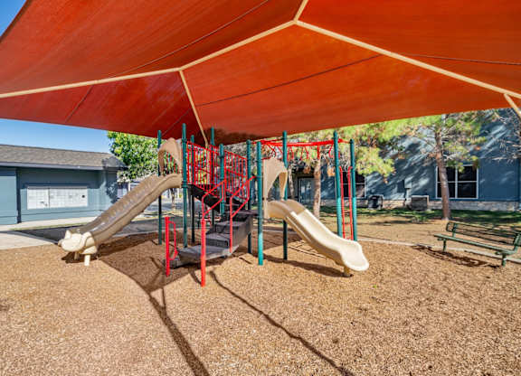 Playground with slides and shade canopy at Houston Street Townhomes Apartments, San Antonio, Texas