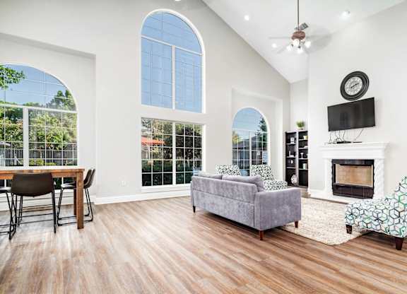 Spacious living room with vaulted ceiling and fireplace at Houston Street Townhomes Apartments, Texas