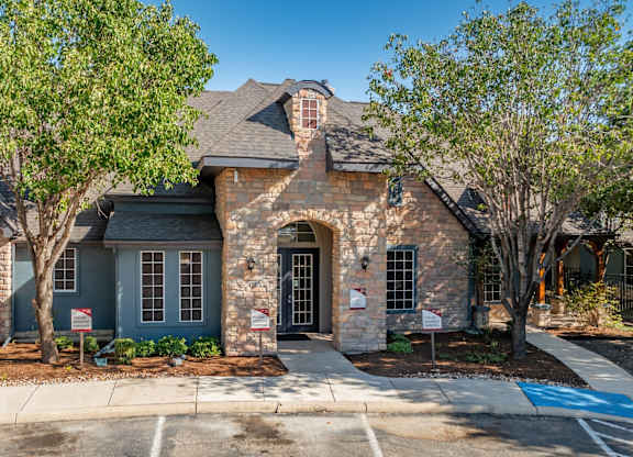 Brick and stone clubhouse exterior with arched entry at Houston Street Townhomes Apartments, Texas, 78220