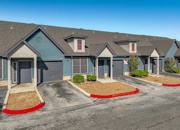 Townhome exteriors with garages and landscaping at Houston Street Townhomes Apartments, Texas, 78220