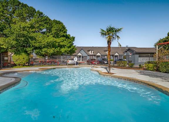 Resort style pool with palm tree and fencing at Houston Street Townhomes Apartments, San Antonio, TX 78220