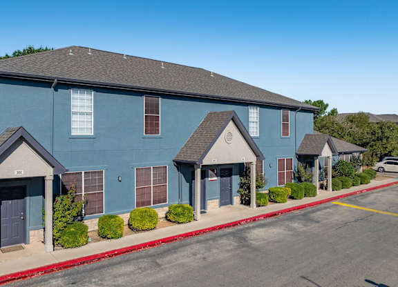 Two story townhome building exterior with gabled entryways at Houston Street Townhomes Apartments, San Antonio, 78220