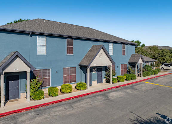 Blue townhome buildings with peaked entry porches at Houston Street Townhomes Apartments, San Antonio, Texas