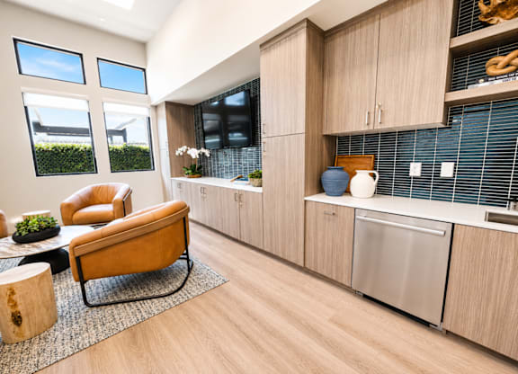 A kitchen with a yellow chair and wooden cabinets.