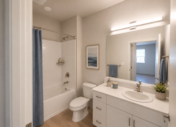 A white bathroom with a blue shower curtain.