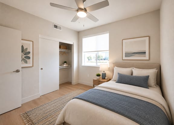 A bedroom with a bed, a ceiling fan, and a window.