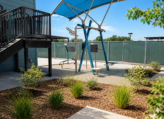 A blue umbrella is in the middle of a garden.