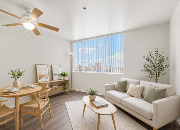 A living room with a couch, table, chairs, and a ceiling fan.