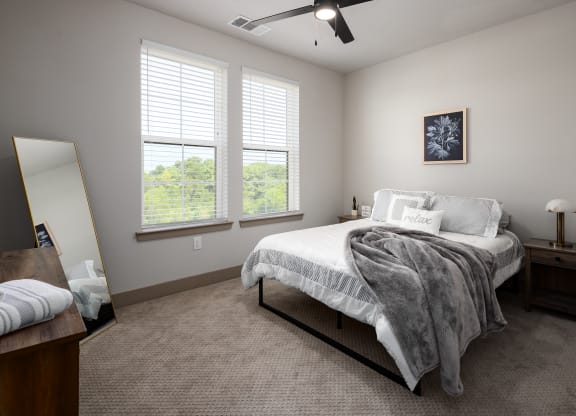 a bedroom with a bed and two windowsat Abberly Foundry Apartment Homes, Nashville, TN, 37206
