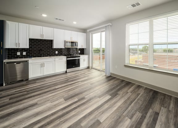 a kitchen with white cabinets and black and white appliances at Abberly Foundry Apartment Homes, Nashville