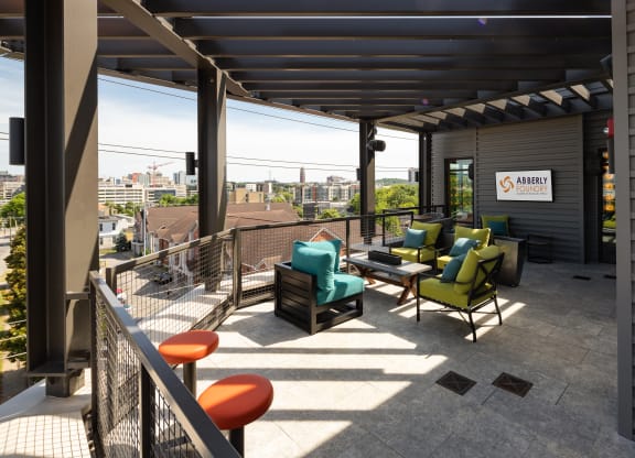 a patio with chairs and a table on top of a buildingat Abberly Foundry Apartment Homes, Nashville, TN