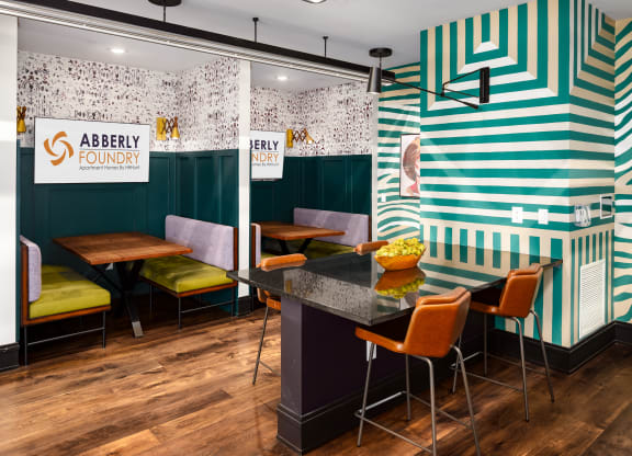 the interior of abbey foundry with green and white walls and a black table with orangeat Abberly Foundry Apartment Homes, Nashville, TN, 37206
