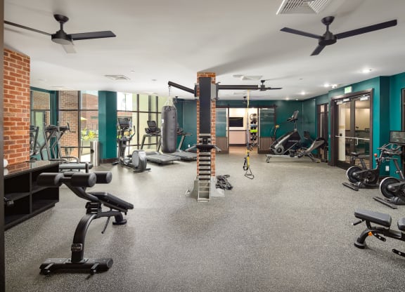 a large fitness room with exercise equipment and green wallsat Abberly Foundry Apartment Homes, Nashville, TN