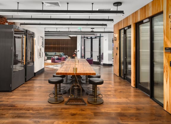 a conference room with a long wooden table and black stools at Abberly Foundry Apartment Homes, Nashville, TN