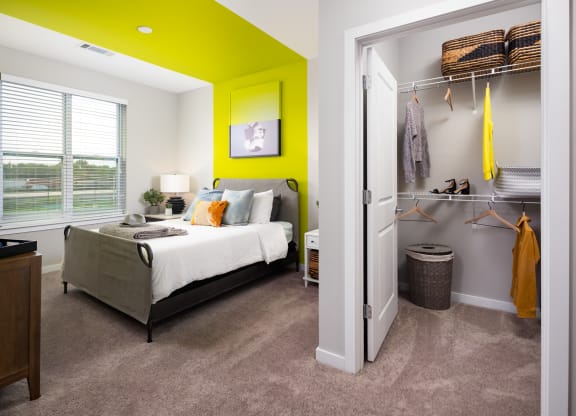a bedroom with a green accent wall and gray carpet  at Abberly Noda Vista Apartment Homes, Charlotte, NC, 28206