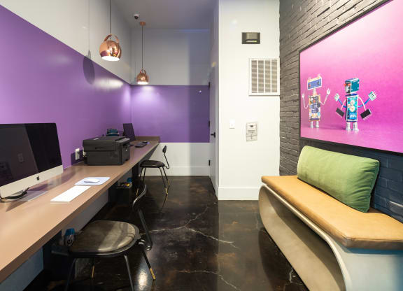 a workspace with two computers and a bench with a green pillow at Abberly Noda Vista Apartment Homes, Charlotte, NC, 28206