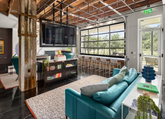 a living room filled with furniture and a large window  at Abberly Noda Vista Apartment Homes, Charlotte