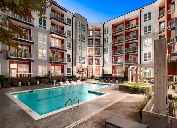 an apartment complex with a swimming pool  at Abberly Noda Vista Apartment Homes, North Carolina
