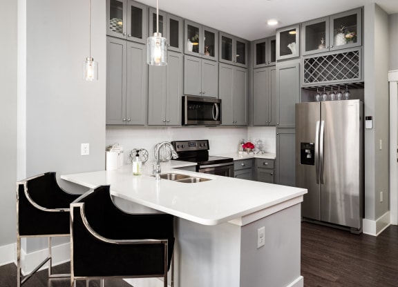 a kitchen with a white counter top and a stainless steel refrigerator  at Abberly Onyx Apartment Homes, Decatur
