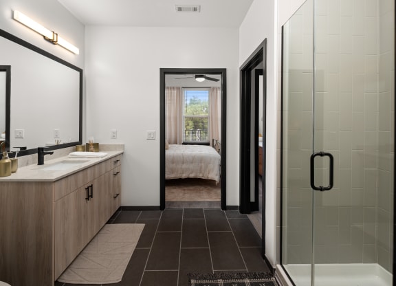 a bathroom with a glass shower stall and a double sink with a large mirror on the wall  at Abberly Riverwalk Apartment Homes, Nashville, Tennessee