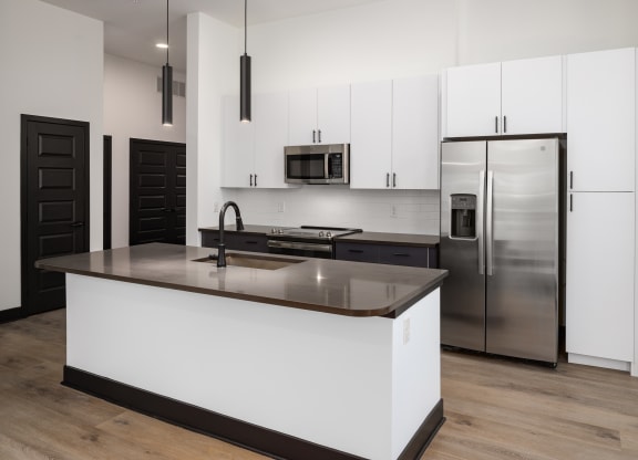 a kitchen with white cabinets and a large island at Abberly Riverwalk Apartment Homes, Tennessee
