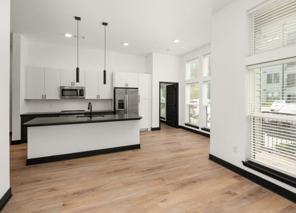 a kitchen and living room with white walls and hardwood floors at Abberly Riverwalk Apartment Homes, Nashville, Tennessee