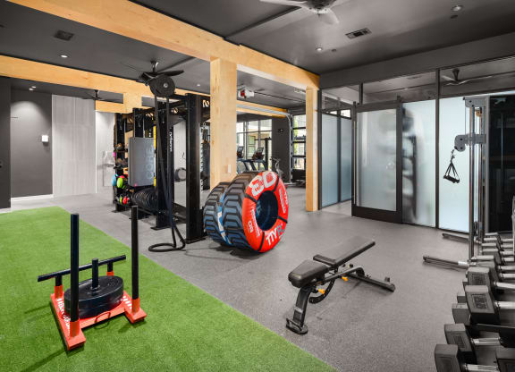 a home gym with a large tire in the middle of the room at Abberly Riverwalk Apartment Homes, Nashville, 37228