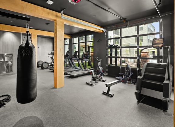a large punching bag hangs from the ceiling in a gym with weights and other exercise equipment at Abberly Riverwalk Apartment Homes, Nashville, 37228