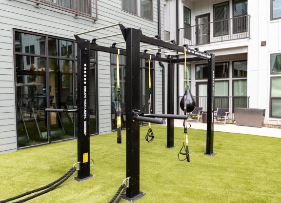 a piece of exercise equipment in the middle of a grassy area in front of a building at Abberly Riverwalk Apartment Homes, Tennessee