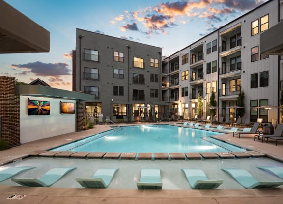 an apartment complex with a swimming pool and chaise lounge chairs at Abberly Riverwalk Apartment Homes, Nashville, TN