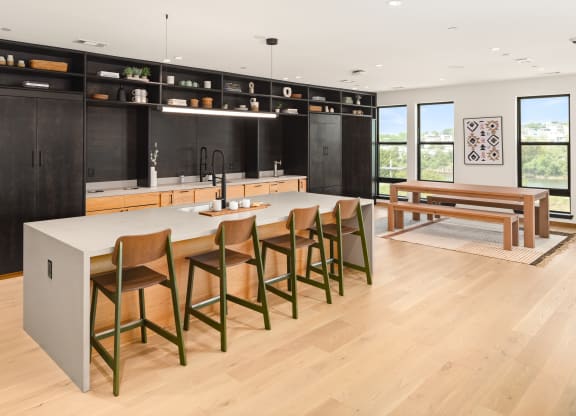 a large kitchen with a large center island with a marble countertop and a wooden dining table  at Abberly Riverwalk Apartment Homes, Nashville, TN